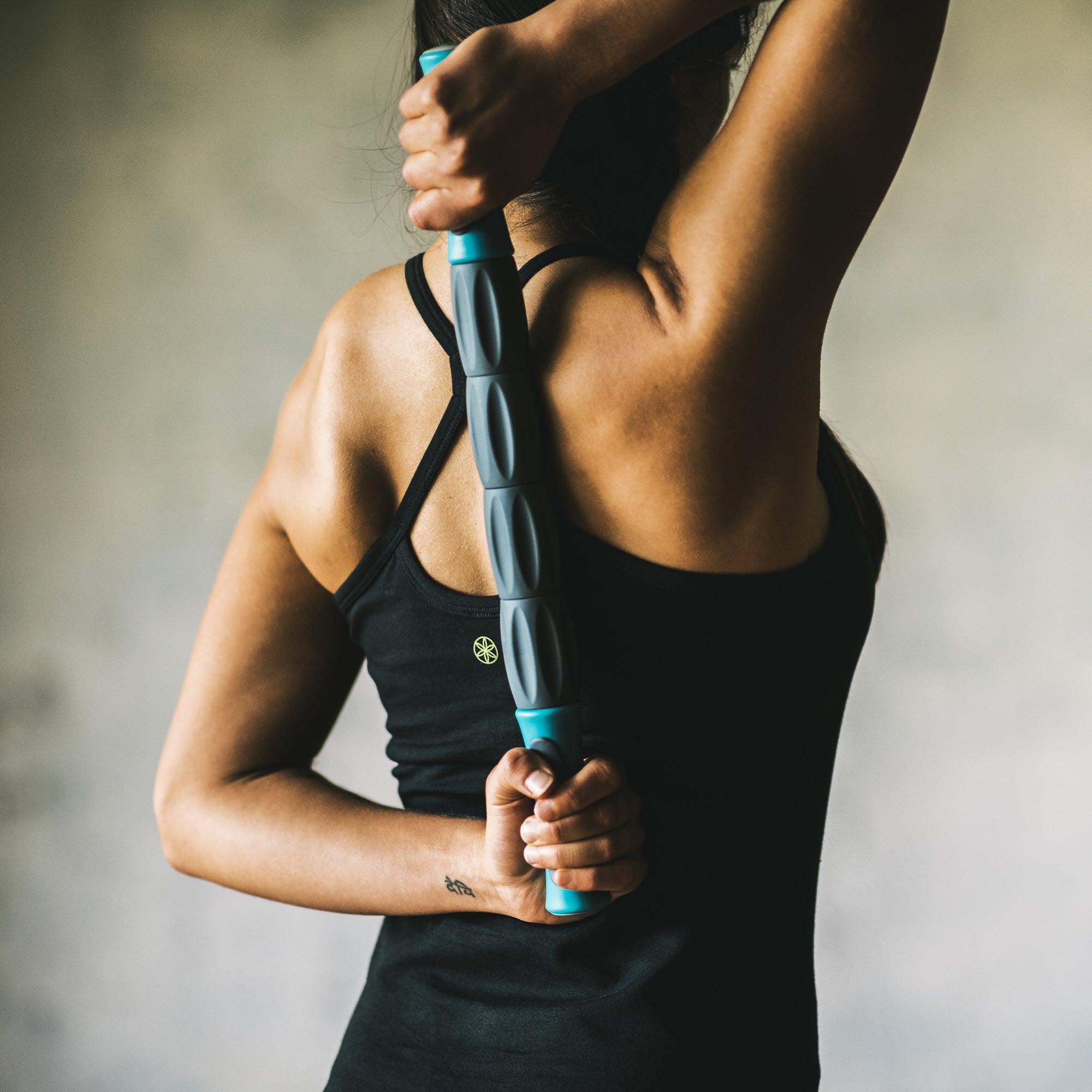 Massaging the back and shoulders with the Total Body Massage Roller